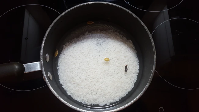 rice, cardamom & cloves in a pan