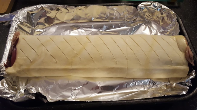 raw sausage roll scored for sausage roll & caramalised onion raw sausage roll scored